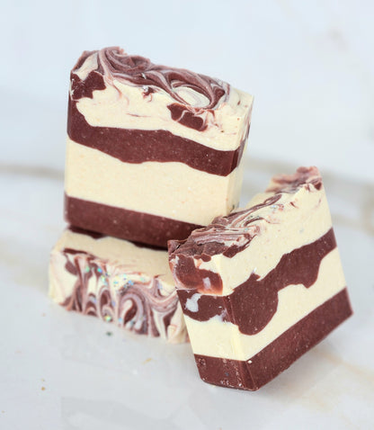 Two swirled red and white soap bars on a white background